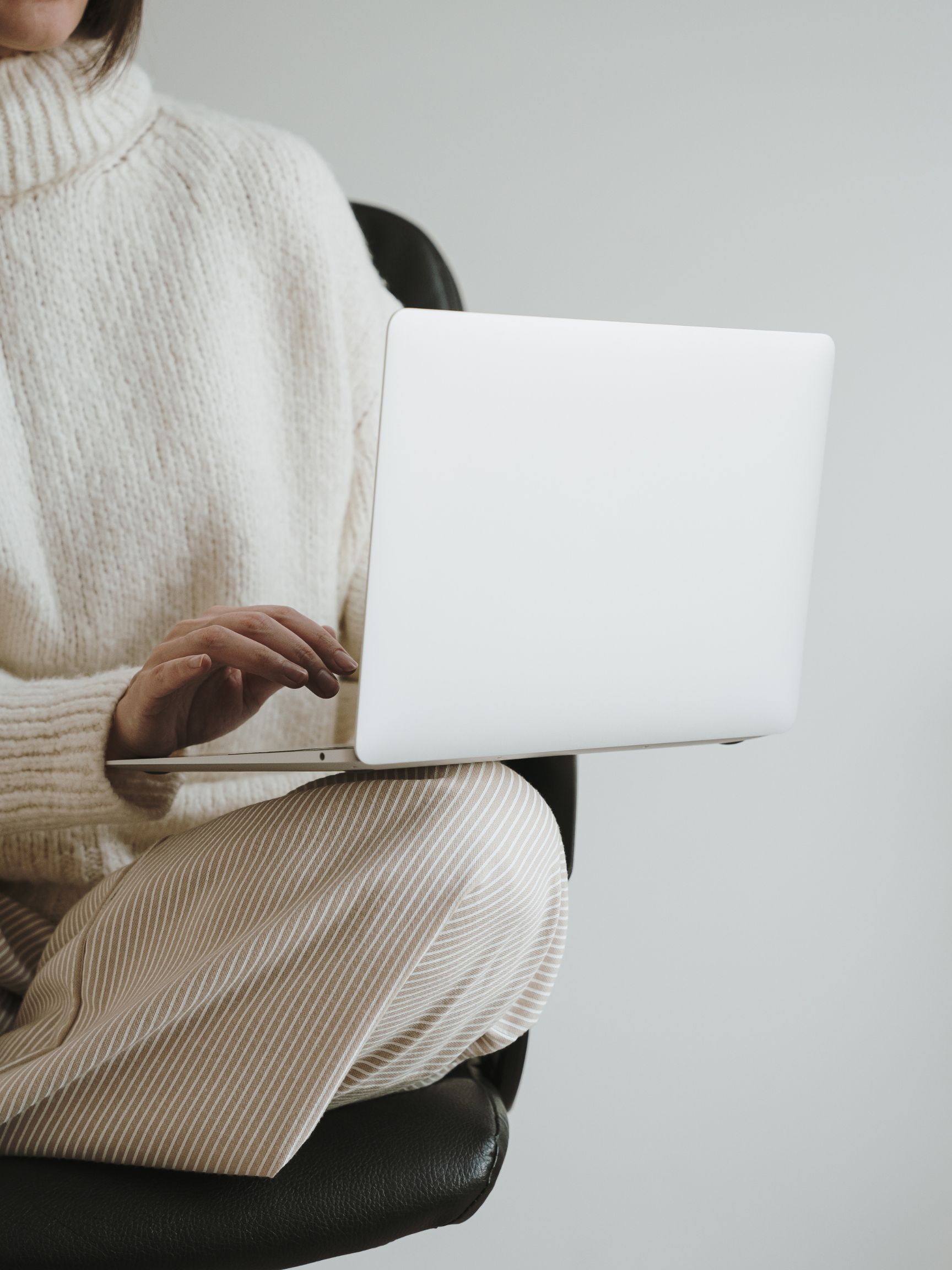 Woman working calmly on a laptop, hands typing